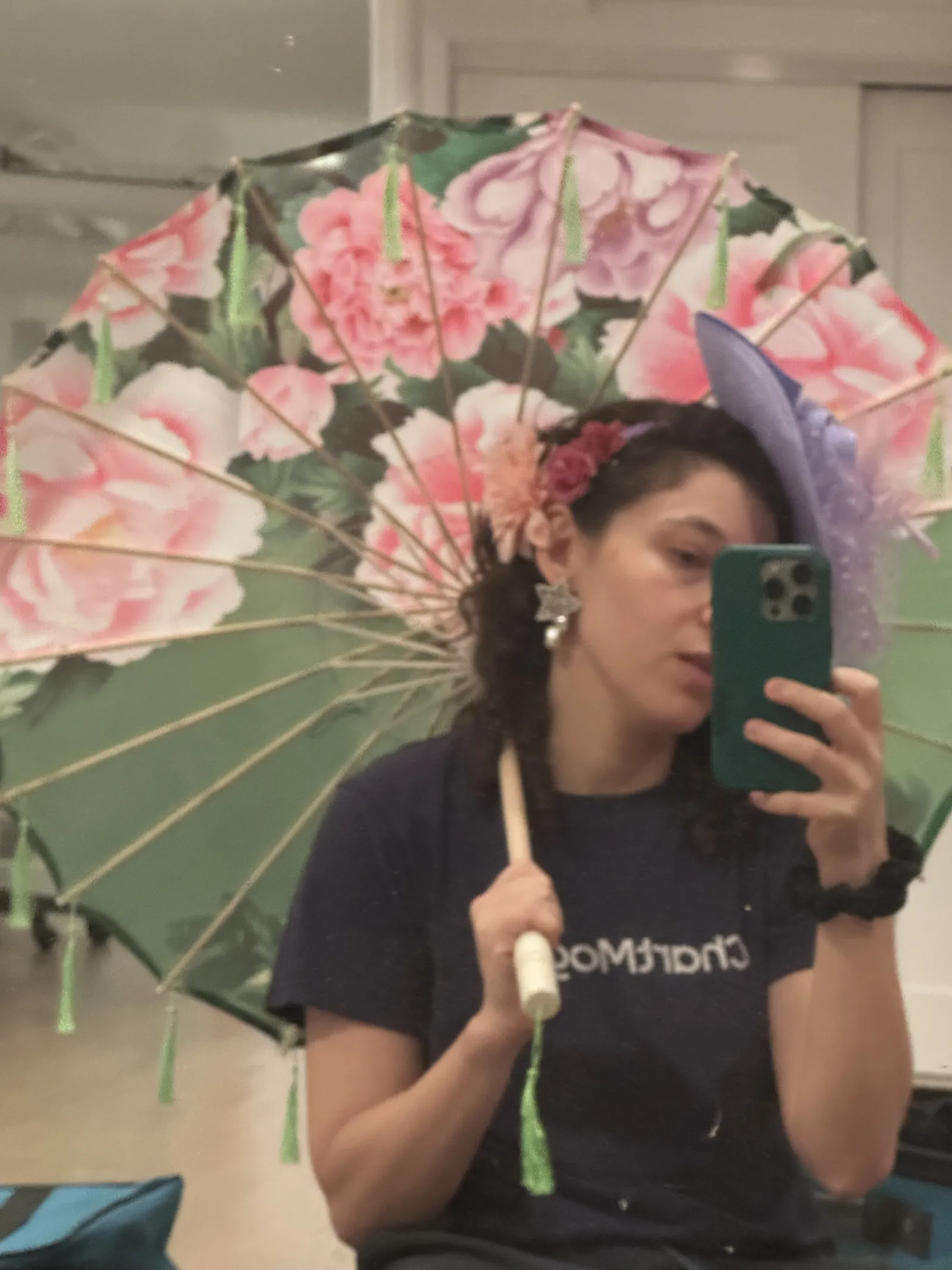 Mirror selfie of a person holding a large floral parasol over their shoulder.