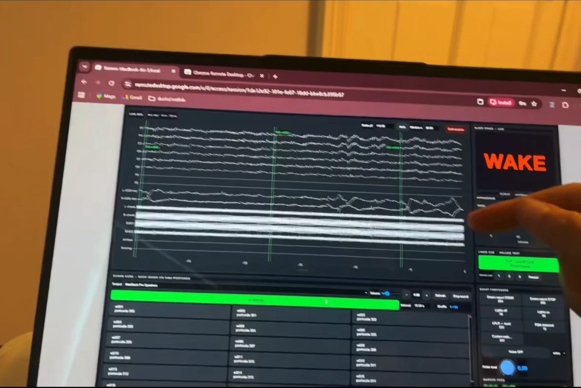 A laptop showing rows of brain-wave lines from the sleeping guest, with a red label reading WAKE on the right.