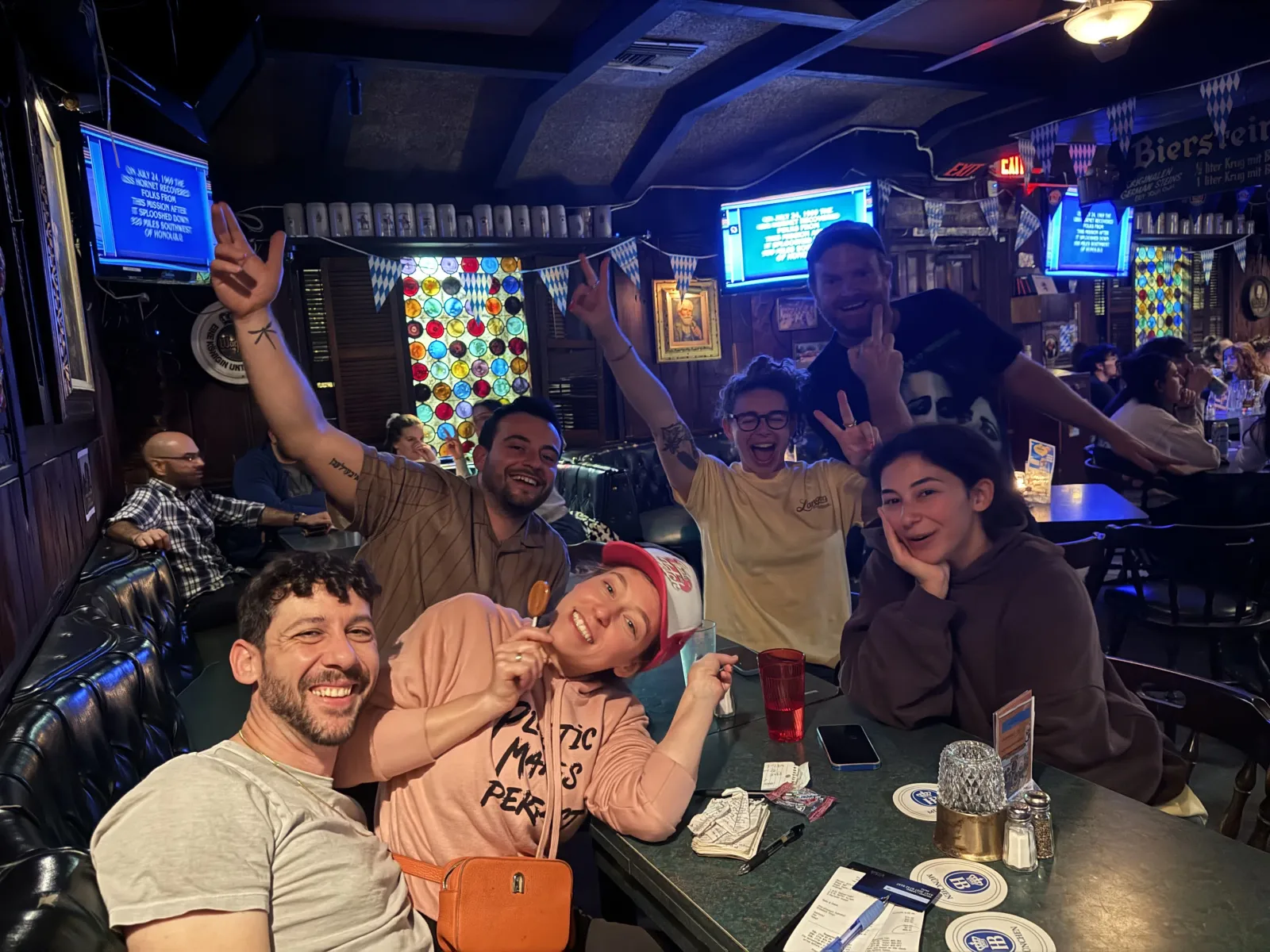 Friends celebrate at a bar after their trivia team wins.