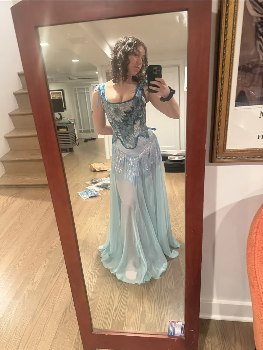 Try-on photo of a sparkly leotard with a blue corset and skirt