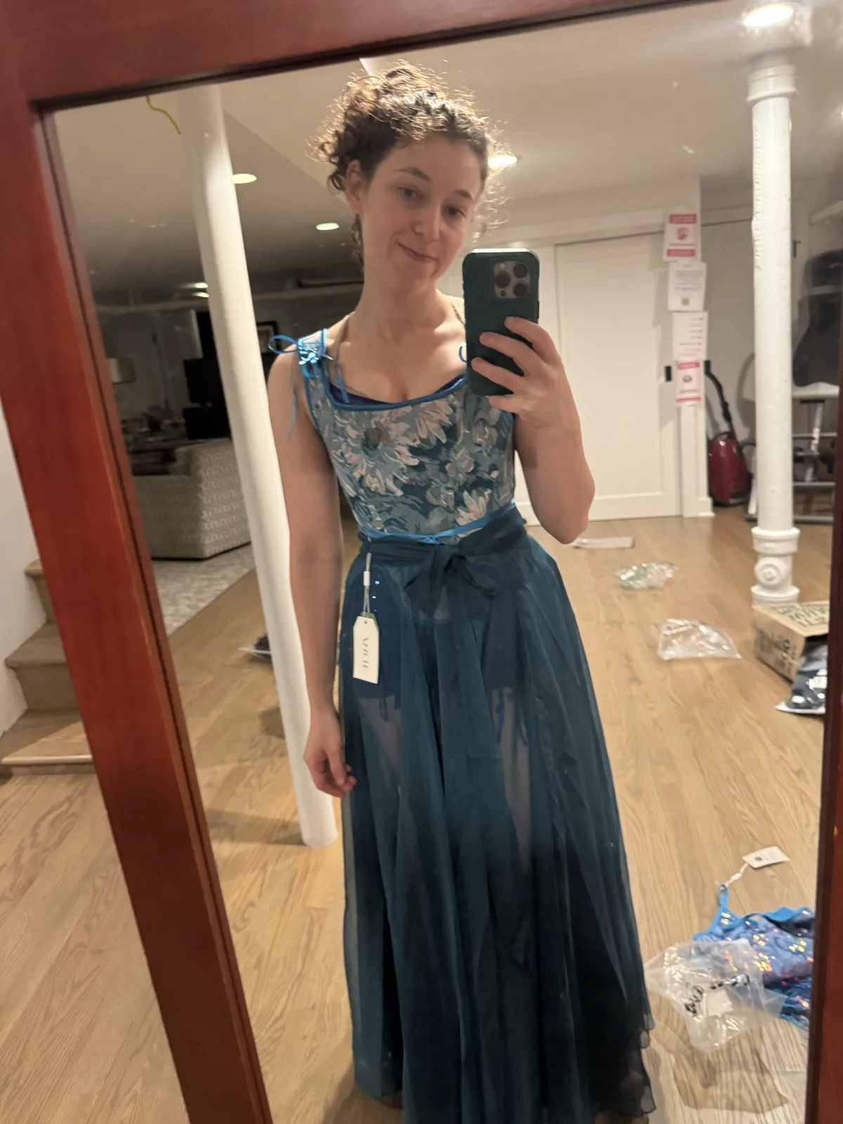 Mirror selfie wearing a blue corset with a full dark teal skirt.